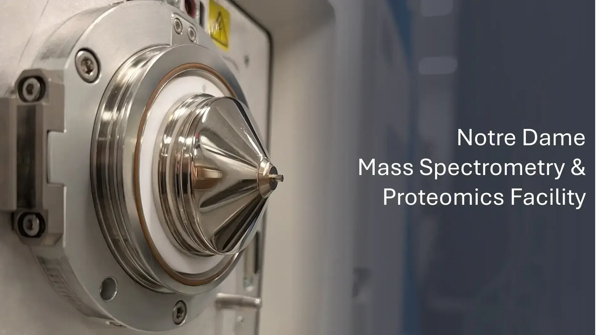 Close-up of the polished silver ion source and nozzle on a mass spectrometer at the Notre Dame Proteomics Facility.